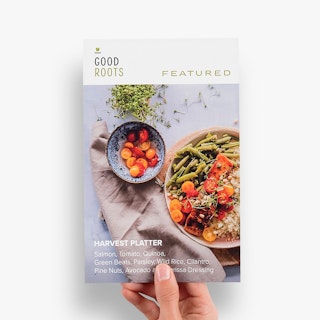 A hand holding a custom menu insert printed with Good Roots and an image of two bowls of food.