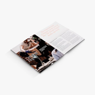 A nonprofit newsletter laying open to people carrying boxes and Creating Hope in white.