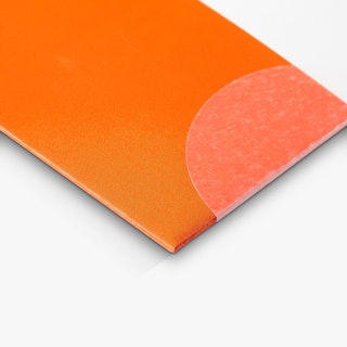 The corner of a newsletter custom printed in orange and white with a transparent wafer seal.