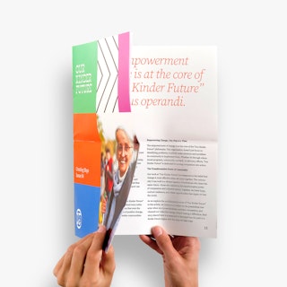 Two hands opening a nonprofit newsletter printed with Our Kinder Future and a multicolored cover.