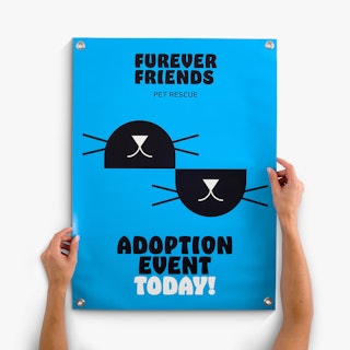 Two hands holding an adoption event banner printed in blue, black and white with silver grommets.