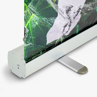 The bottom of a retractable banner stand with a green and white banner coming out of it.