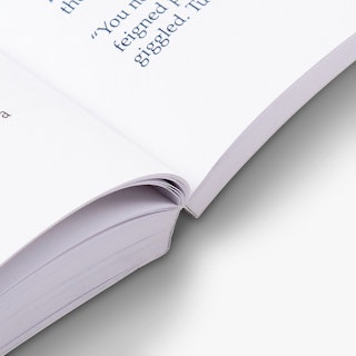 The spine of a paperback book laying open with a perfect binding and black text.