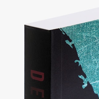 The top left corner of a paperback book printed with a black, red and blue-green cover design.