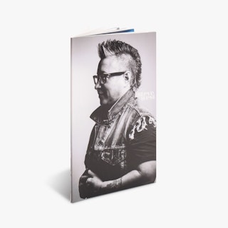 A custom photography booklet printed with a perfect binding and a person with a mohawk and glasses in black and white on the cover.
