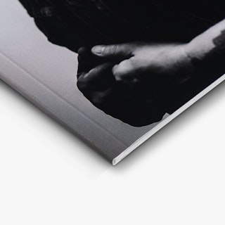The bottom left corner of a photography booklet printed with a black and white cover and a perfect binding.