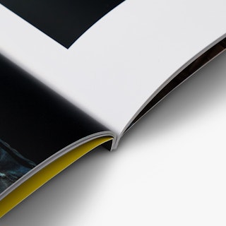 A photography booklet laying open with a perfect binding.