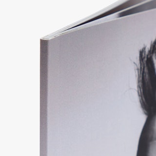 The top left corner of a photography booklet printed with a black and white cover and a perfect binding.