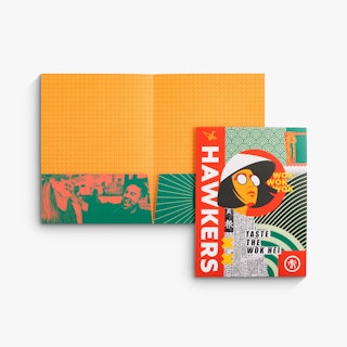 A pocket folder laying open with another closed one overlapping it with orange and green designs.