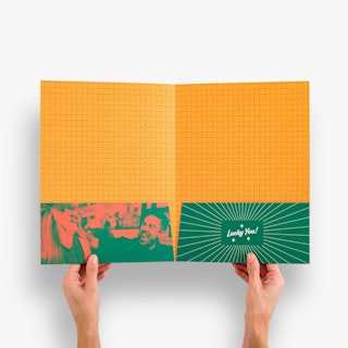 Two hands holding open a pocket folder printed in orange and green with an image of two people eating.
