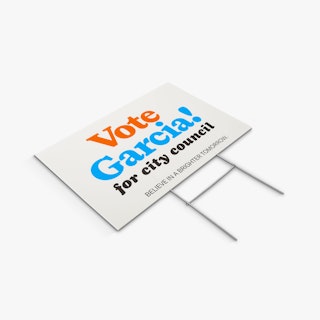 A political lawn sign and H-stake laying flat with Vote Garcia for City Council in orange, blue and black.