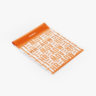 A custom poly mailer laying flat and printed with Threadwell repeated in orange and white.