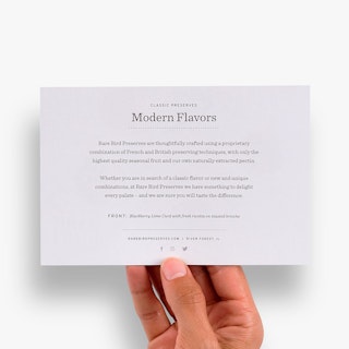 A hand holding a custom postcard printed with Classic Preserves Modern Flavors and brand info.