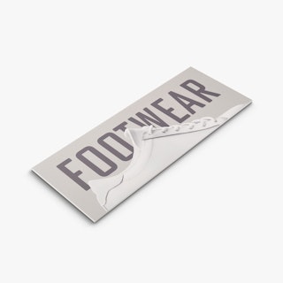 A PVC foam board sign laying flat and custom printed with Footwear in gray and a white sneaker.