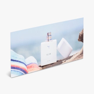 A custom rack card printed with a perfume bottle next to a beach towel.