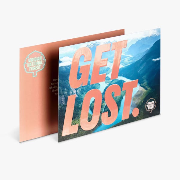 Two spot UV greeting cards overlapping each other and printed with a nature scene and Get Lost in orange.