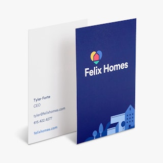Two real estate business cards overlapping each other and printed with Felix Homes on a dark blue background.