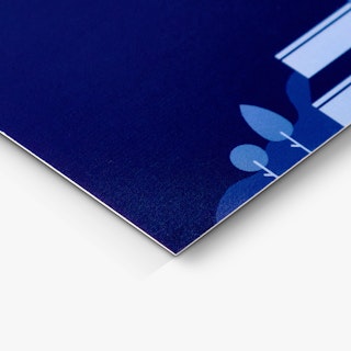The bottom corner of a business card printed with a dark blue background and light blue illustrations.