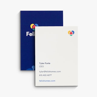 Two real estate business cards overlapping each other with a dark blue front, white back and Felix Homes information.