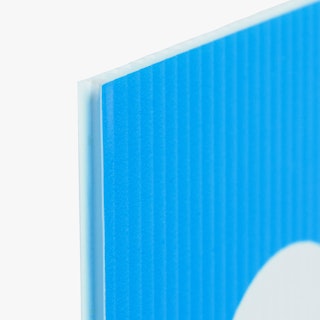 The corner of a custom lawn sign printed on corrugated plastic in blue and white.