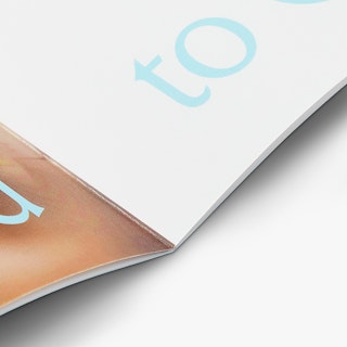 A church booklet laying open with a saddle stitch binding and pages with a tan, white and blue design.