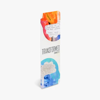 A religious bookmark printed with orange and blue designs and Transformed Romans 12:2 on the front.
