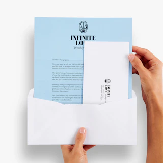 Two hands holding a religious letter mailer and reply envelope coming out of a white envelope.