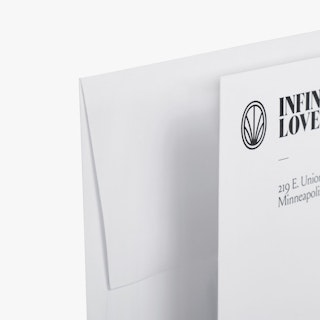 The corners of two offering envelopes printed with Infinite Love and an address in black.