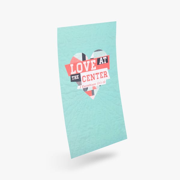 A church poster printed with a light teal background and Love at the Center with a heart design.