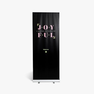 A church pop up banner printed with a black background and Joyful in pink with a silver stand.