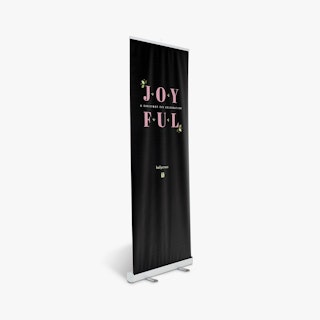 A church retractable banner printed with a black background and Joyful in pink.