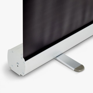 The bottom of a silver retractable banner stand with a black banner coming out of it.