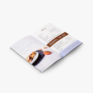 A custom brochure laying open and printed with a menu and an image of beignets on a plate.