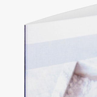 The top corner of a custom brochure printed with a light gray, pale blue and white design.