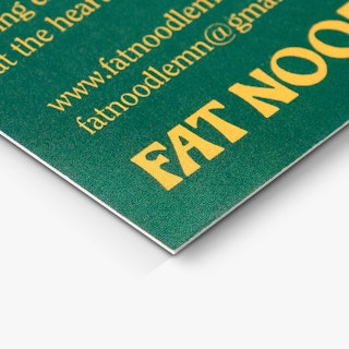 The bottom corner of a restaurant business card printed with a green background and Fat Noodle in yellow.