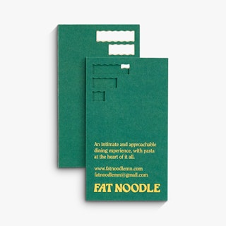 Two business cards custom printed with a green background, three die cuts at the top and Fat Noodle.