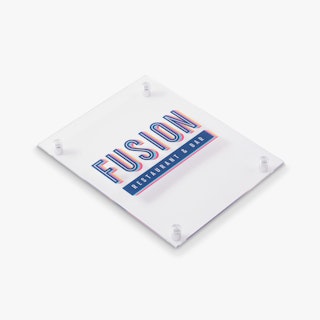 A custom acrylic sign laying flat and printed with Fusion Restaurant & Bar in red and blue.
