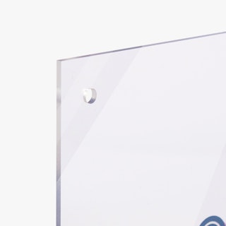 The top corner of a clear acrylic sign printed with a blue design and a hole for an aluminum standoff.