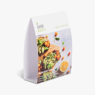 A restaurant table tent printed with Good Roots in black and green and an image of avocado toast.