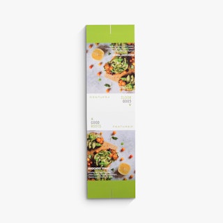 An unfolded restaurant table tent laying flat with images of avocado toast and a green and white design.