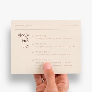 A hand holding an RSVP card with lines for guest names and four boxes to check for attendance.