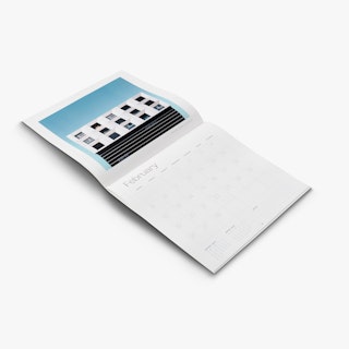A saddle stitched calendar laying flat open to an image of a white building against a blue background.