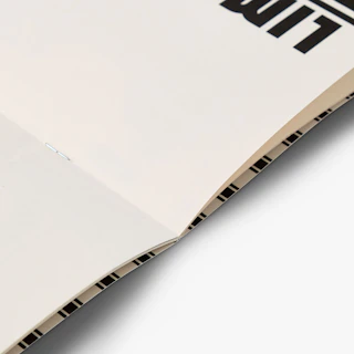 A custom menu printed with a saddle stitch binding laying open to black and white interior pages.