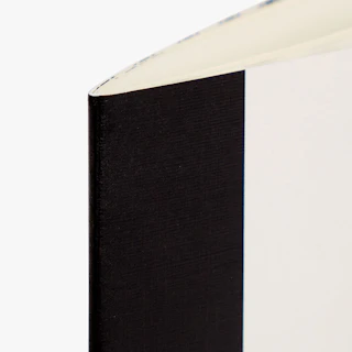 The top corner of a saddle stitch menu printed with a black and white cover.