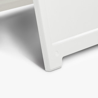 The bottom corner of a white A-frame sandwich board sign.