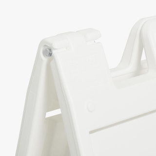 The top corner of a white A-frame sandwich board sign.