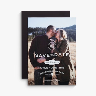 Two save the date magnets overlapping each other with a couple smiling and standing in a field.