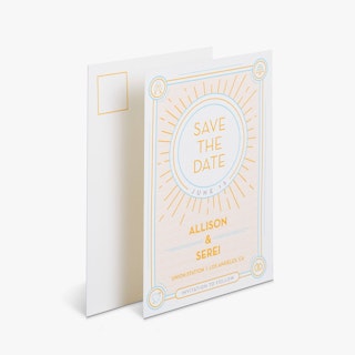 Two save the date postcards overlapping each other with a blue and yellow sun design on the front.