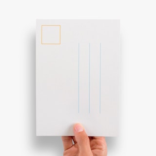 A hand holding a save the date postcard printed with blue address lines and a yellow stamp outline.