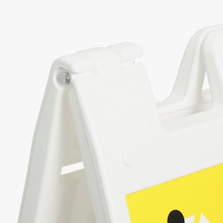 A white sandwich board sign holding a printed sign with a yellow and black design.